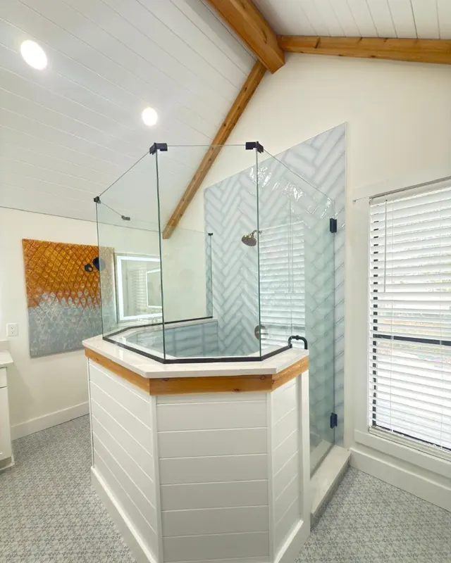 Neo-angle glass shower enclosure under a vaulted ceiling in a Jacksonville bathroom