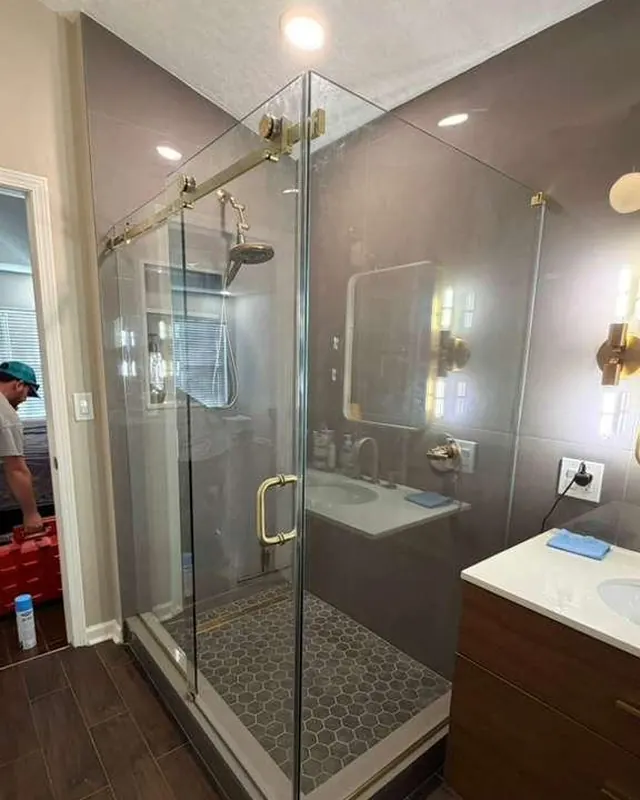 Frameless corner shower with gold hardware in a remodeled master bathroom