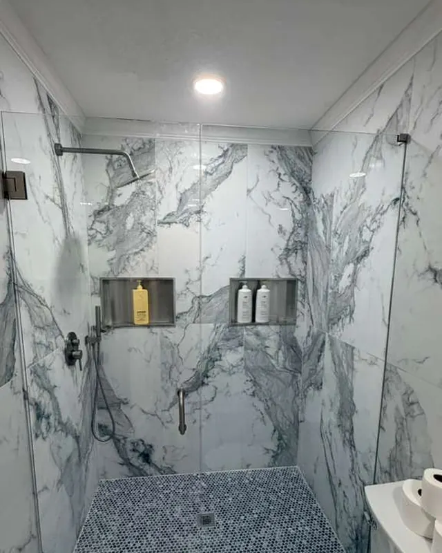 Marble walk-in shower with frameless glass and matte black fixtures